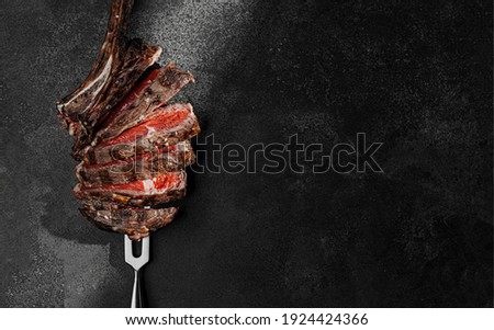 grilled beef steak on a dark background. expensive marbled beef of the highest grade fried to rare on the grill