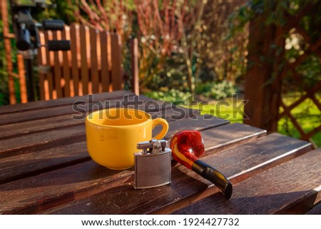 pipe and coffee cup on wooden table 