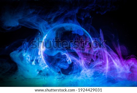 
Swirling clouds of colored light around a sphere on a dark background