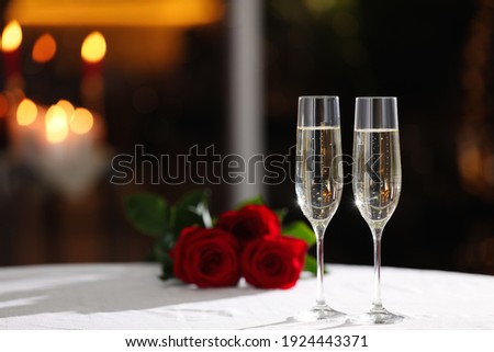 Glasses of champagne on table in restaurant, space for text. Romantic dinner