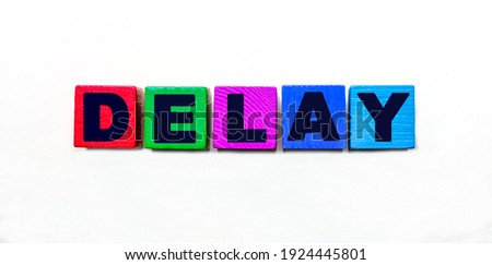 The word DELAY is written on colorful cubes on a light background