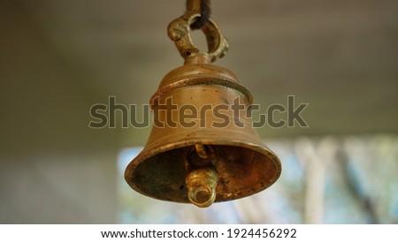 New bronze bell in indian temple isolated on blur background. Close-up of Hindu temple brass bell hanging in gold color