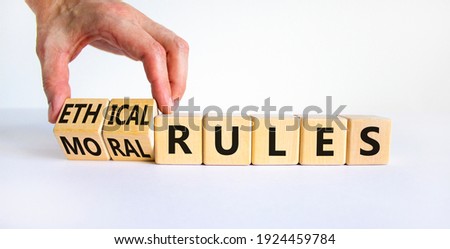 Ethical or moral rules symbol. Businessman turns wooden cubes and changes words ethical rules to moral rules on a beautiful white background. Business and ethical or moral rules concept. Copy space.