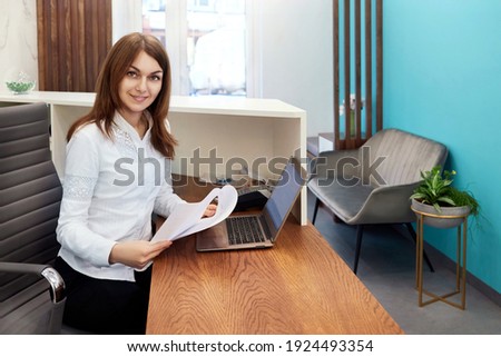 Smiling happy woman workingt at reception in a hospital, girl at the reception in the office, administration