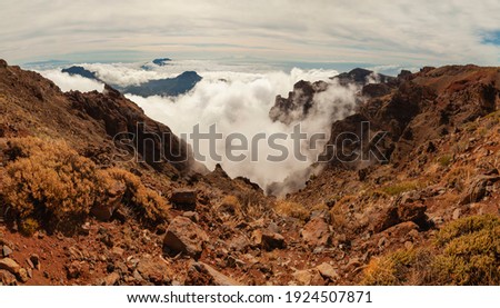 Impressive panoramic landscape of clouds and volcanic mountains from the top of the Roque de los Muchachos viewpoint, on the island of La Palma, Canary Islands, Spain.