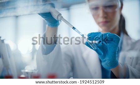 Medical Research Laboratory: Portrait of a Beautiful Female Scientist Using Micro Pipette for Analysis. Advanced Scientific Lab for Medicine, Biotechnology, Microbiology Development. Hands Close-up Royalty-Free Stock Photo #1924512509