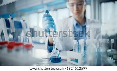 Medical Research Laboratory: Portrait of a Beautiful Female Scientist in Goggles Using Micro Pipette for Test Analysis. Advanced Scientific Lab for Medicine, Biotechnology, Microbiology Development Royalty-Free Stock Photo #1924512599