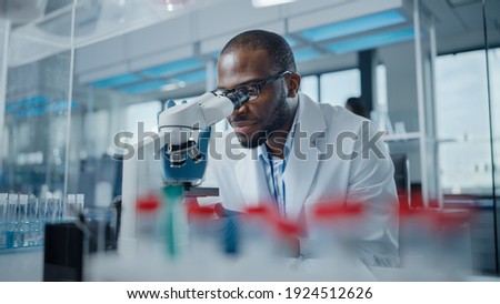 Modern Medical Research Laboratory: Portrait of Male Scientist Looking Under Microscope, Analysing Samples. Advanced Scientific Lab for Medicine, Biotechnology, Microbiology Development Royalty-Free Stock Photo #1924512626