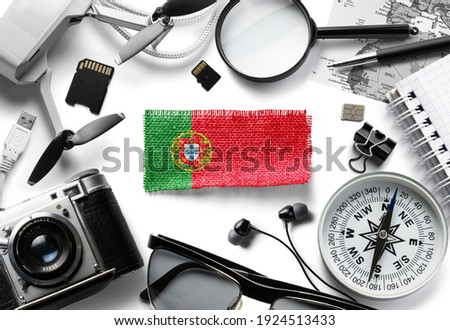 Flag of Portugal and travel accessories on a white background.