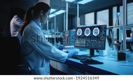 Modern Medical Research Laboratory: Portrait of Female Scientist Working on Computer, Showing MRI Brain Scans. Advanced Scientific Lab for Brain Development. Dark Evening