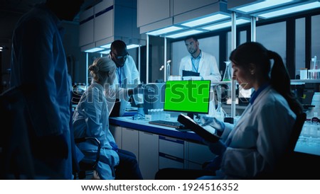 Medical Research Laboratory Meeting: Diverse Team of Scientists Use Personal Computer Showing Green Chroma Key Screen. Advanced Lab for Medicine, Technology Development. Blue Evening Shot