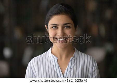Profile picture of smiling young Indian woman client or customer feel satisfied with good quality service. Headshot portrait of happy millennial mixed race female teacher or coach. Diversity concept.