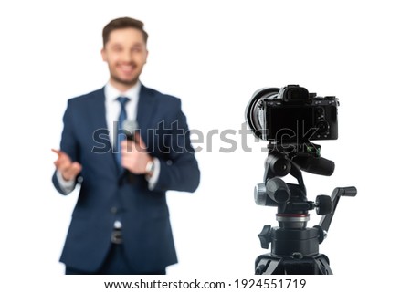 selective focus of digital camera near news anchor on blurred background isolated on white Royalty-Free Stock Photo #1924551719