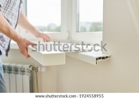 Artificial stone window sill, installation, technological process. Repair, construction of house, apartment. Close up of worker's hand with tools and parts Royalty-Free Stock Photo #1924558955