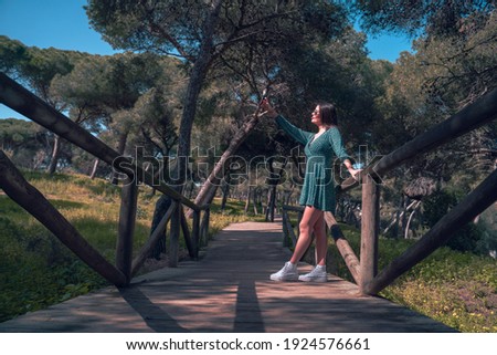 happy young woman in nature with mobile phone
