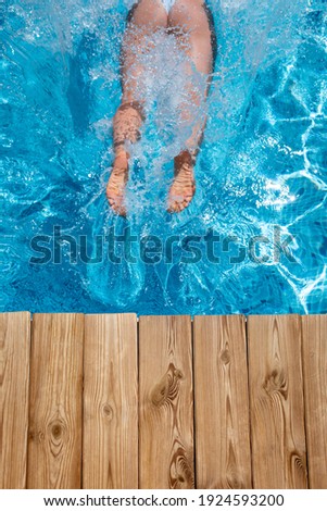 Happy woman having fun on summer vacation. Girl jumping in swimming pool. Active healthy lifestyle concept. Spring break!