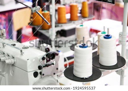 Spools of thread and sewing machines in a workshop