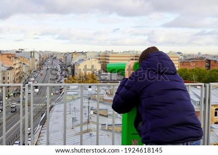 Man looking through binoculars from the top. High quality photo