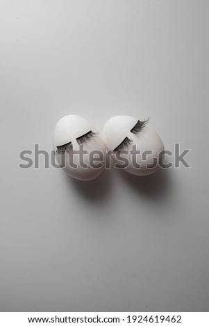 white eggs with eyelashes. creative concept of easter