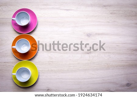 Three cups on a light wooden background. Top view Multicolored coffee cups. Relaxation.
