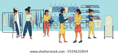 Young women talk to each other in a clothing store. People are shopping, trying on new clothes. Shopping.
