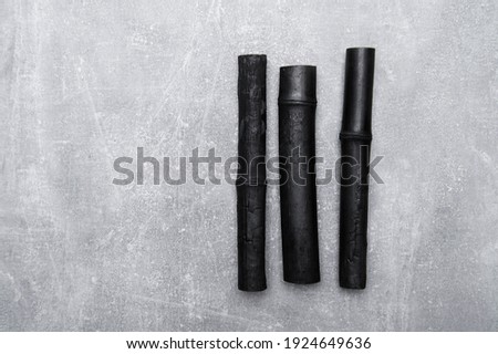 Natural activated bamboo charcoal on concrete background. Realistic pieces charcoal.