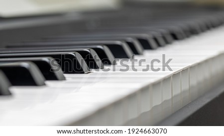 Selective focus on a key of an electric piano keyboard with intentional defocused blur to provide room for text.