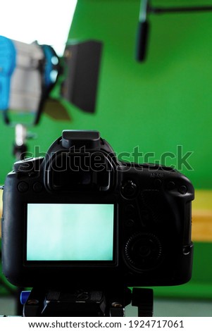 Filming set up with a camera, lights and a green screen