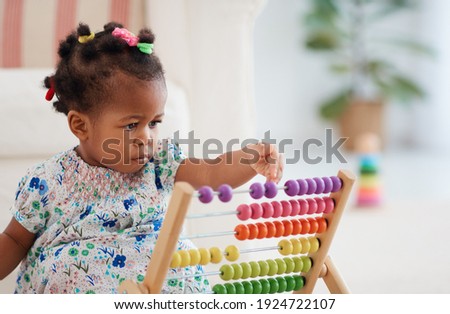 cute african american baby girl playing colorful abacus toy at home Royalty-Free Stock Photo #1924722107