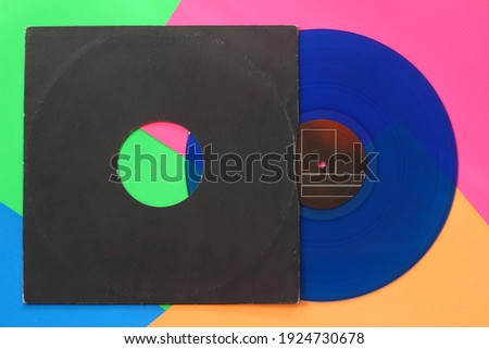  Aged black paper cover and blue vinyl LP record isolated on colorful background