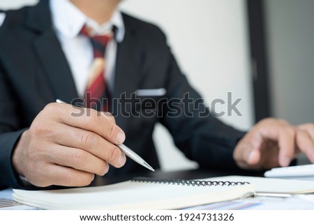 Close up of hand Asian male finance businessman signing a contract. About the financial business in the office. 