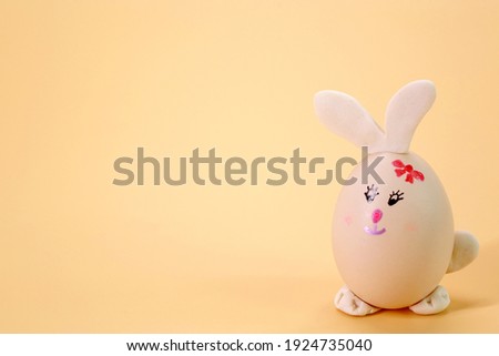 Funny Bunny Easter eggs isolated on beige color background. Selective focus with copy space