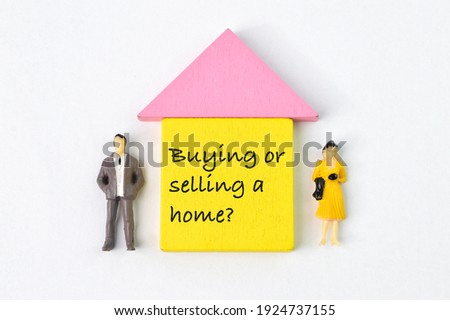 People miniatures and toy wooden house written with question BUYING OR SELLING A HOME?