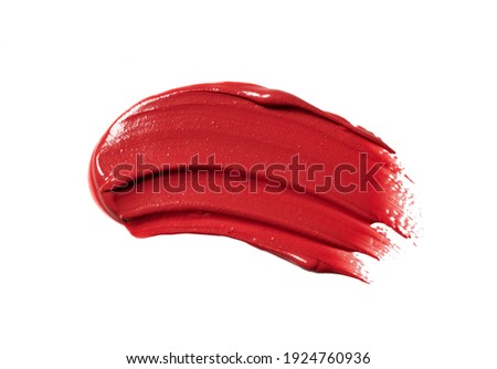 Red lipstick texture on white background. Cream makeup texture. Bright red cosmetic product brush stroke sample.