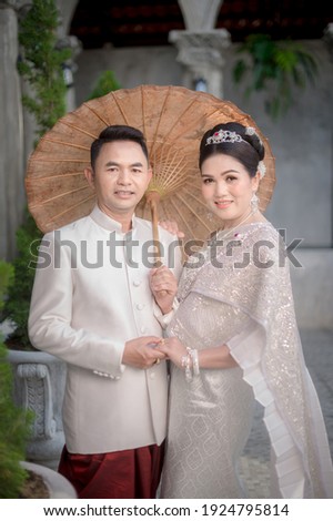 Asian couples happily take pre-wedding pictures with a Thai suit a before getting married.