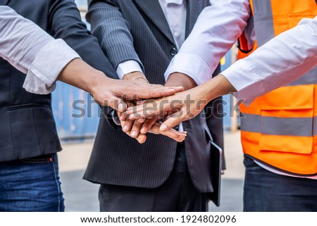 Group of employees and management team wearing logistic uniforms for exporting products abroad, stand to put your hands up and raise your hands together for a harmonious work experience Royalty-Free Stock Photo #1924802096
