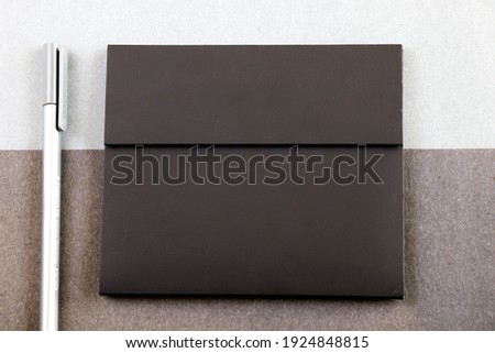 Grey pen and black letter envelope on the black and gray papers background and texture, gray gradient