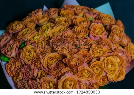 A bouquet of roses wrapped in decorative paper on a dark background