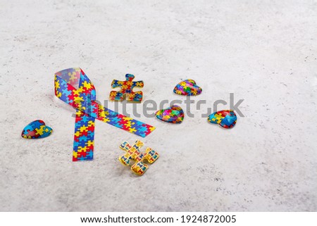 Autism awareness symbols - ribbon with colorful jigsaw pattern, puzzles and heart sign. World Autism spectrum disorder Awareness Day, pride, jigsaw. White background. Copy space