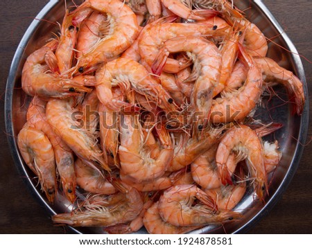 The above picture of shrimp or prawn That was made by steaming or boiling or baking, was placed in a large silver pan. The brown wooden floor looks delicious and ready to be eaten. Deliciously Happy