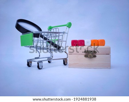 Picture of a green trolley, magnifying glass and color cube on the wooden box.