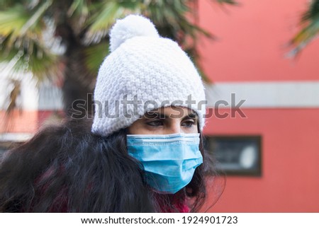 Young latin girl wearing medical mask  at the city