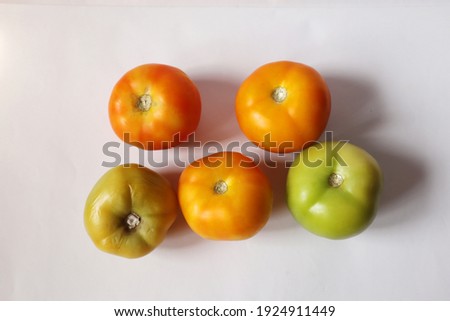 Home grown fresh tomato orange green unripe tomato close up focus blur at the back. A group of colourful isolated white background. Organic vegetables fruits. Top view from above.