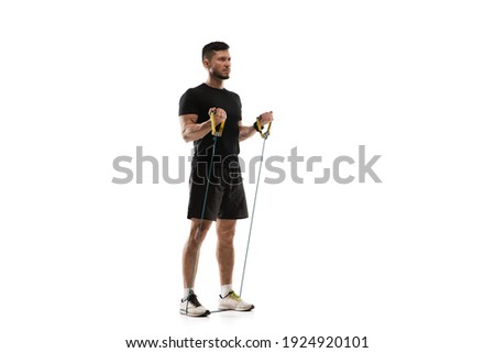 Stretching. Caucasian professional sportsman training isolated on white studio background. Muscular, sportive man practicing. Copyspace. Concept of action, motion, youth, healthy lifestyle.