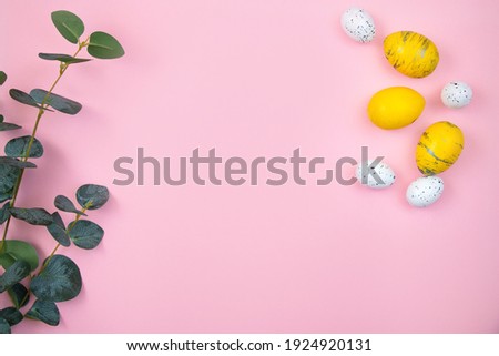 Happy easter concept. Yellow eggs and a branch of eucalyptus on a pink pastel background. Flat lay, top view, copy space.