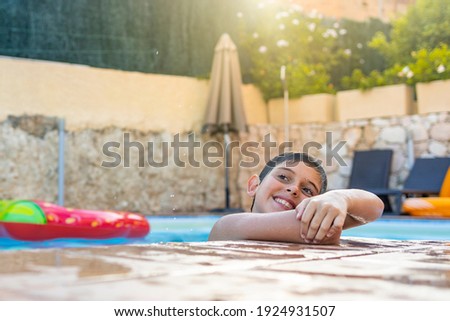 Funny kid smiling on a pool side
