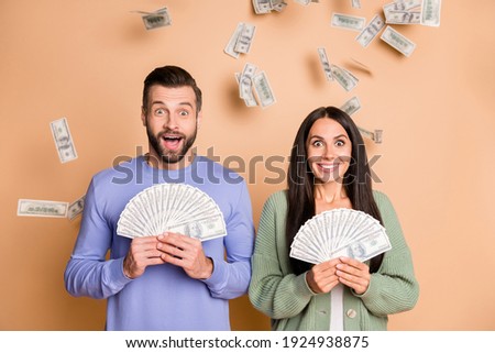 Photo of impressed couple hold money wear sweater isolated on beige color background