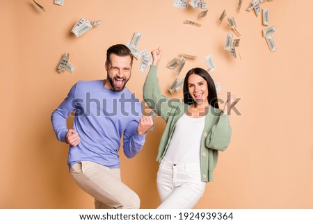 Photo of optimistic nice couple win money wear sweater pants isolated on beige color background