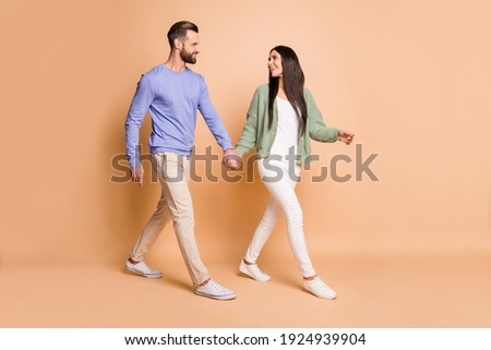 Full size profile photo of optimistic couple go look wear sweater isolated on beige color background Royalty-Free Stock Photo #1924939904