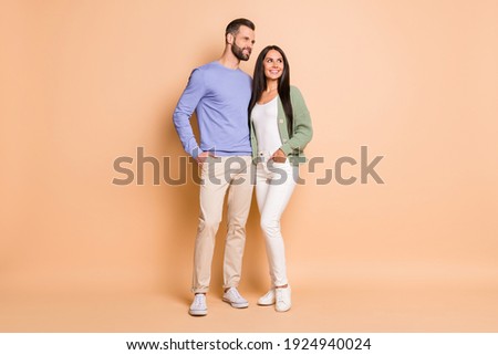 Full size photo of optimistic nice couple stand look empty space wear sweater isolated on beige color background Royalty-Free Stock Photo #1924940024